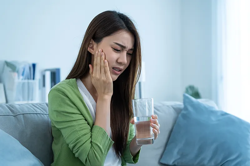 Asian beautiful woman feel terrible toothache after drink cold water. Dental emergency
